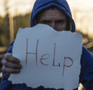 Man with sign asking for HELP