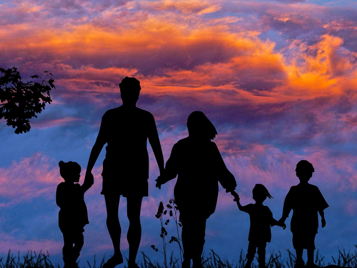 silouette of family of five walking at sunset