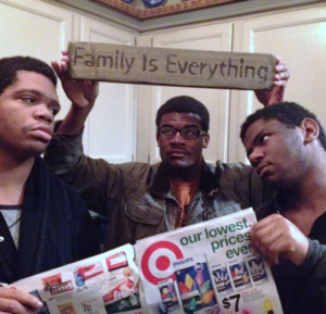 three young men with Target ad and "family is everything" sign