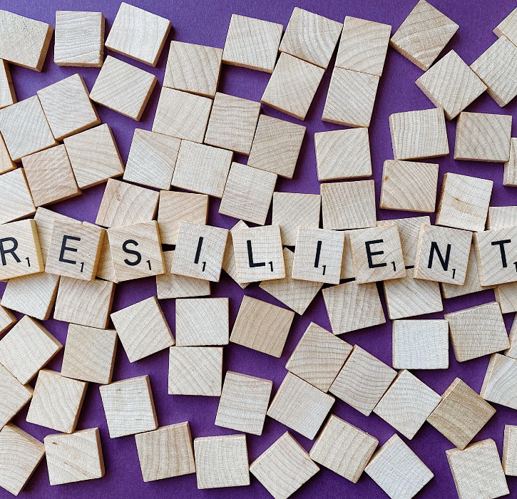 scrabble tiles spelling resilient on a purple background