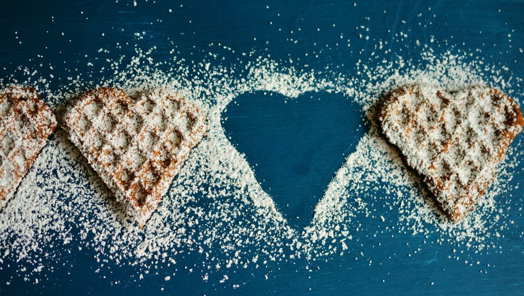 Waffles in the shape of hearts with sugar sprinkled on top